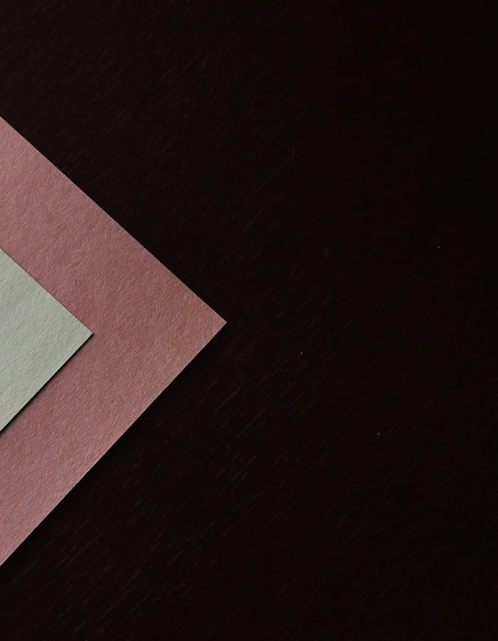 From above of colorful empty sheets of paper placed on black surface in studio